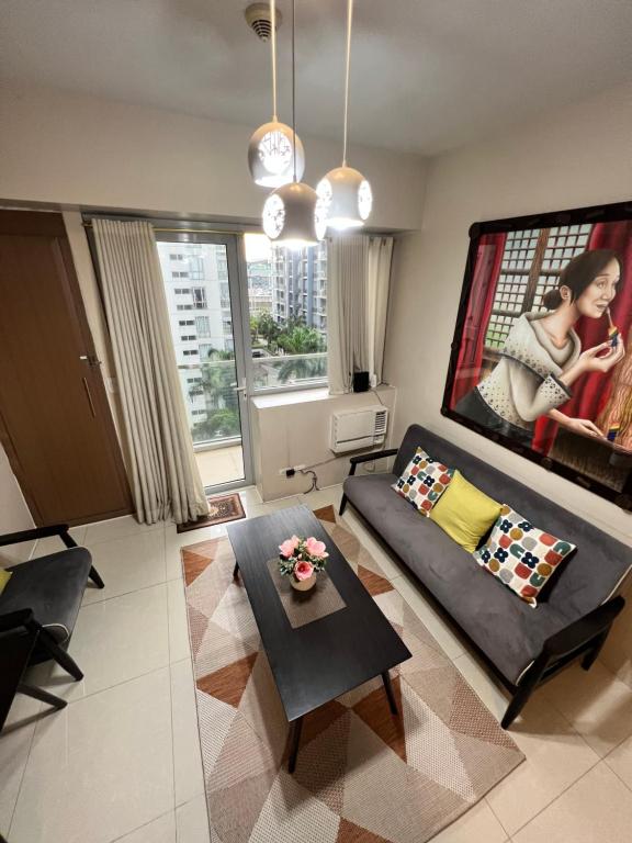 sala de estar con sofá y mesa en Resorts World Condo en Manila