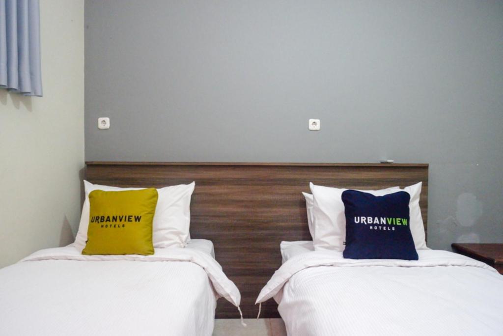 Postel nebo postele na pokoji v ubytování Urbanview Resort Kampoeng Media Yogyakarta by RedDoorz
