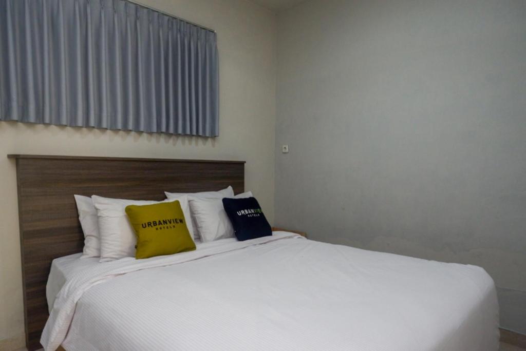Postel nebo postele na pokoji v ubytování Urbanview Resort Kampoeng Media Yogyakarta by RedDoorz