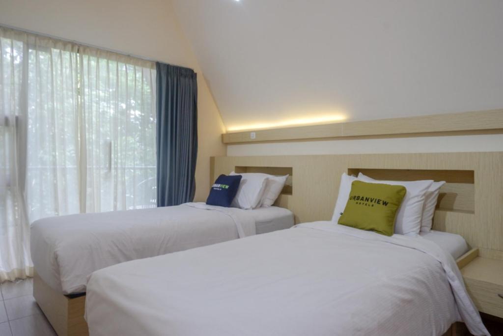 Postel nebo postele na pokoji v ubytování Urbanview Resort Kampoeng Media Yogyakarta by RedDoorz