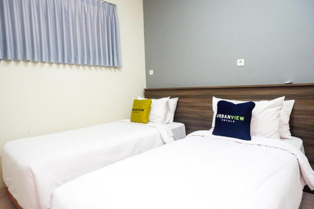Postel nebo postele na pokoji v ubytování Urbanview Resort Kampoeng Media Yogyakarta by RedDoorz