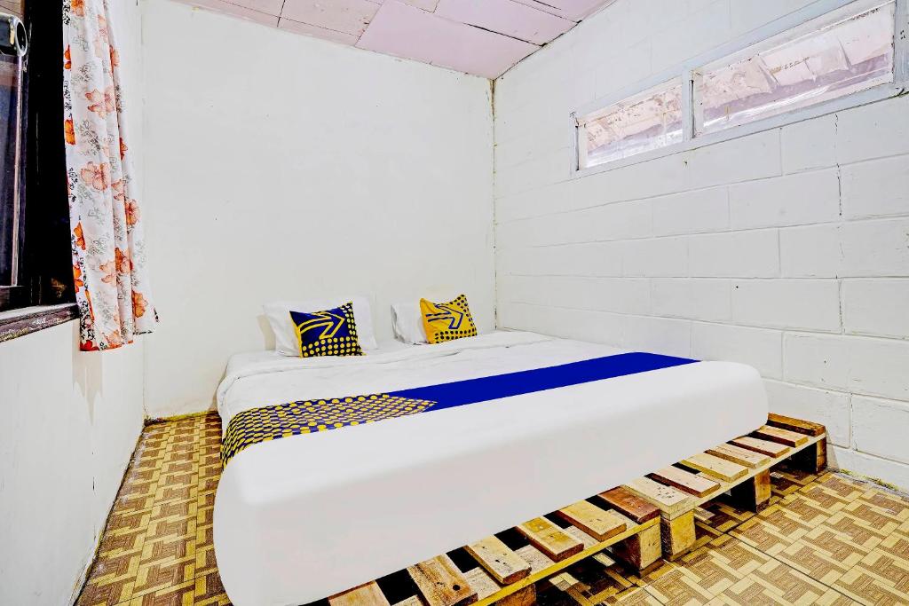 Habitación blanca con cama grande. en SPOT ON 91320 Pondok Elia Syariah, en Bandung