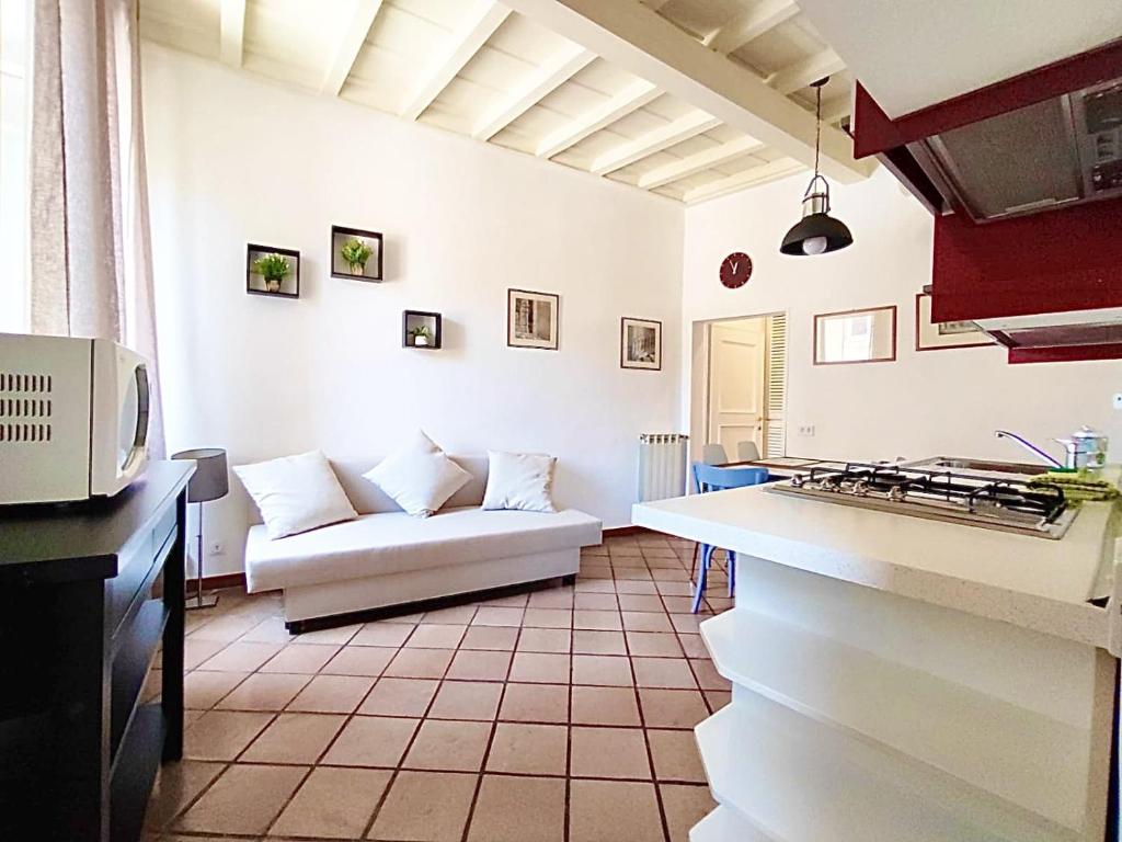 uma sala de estar com um sofá branco e uma cozinha em Trastevere Rome’s Heart charming apartment 88 em Roma