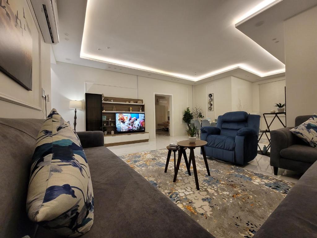 a living room with a couch and a tv at دور واسع وفخم متكامل قرب لافاندا بارك in ‘Aryam