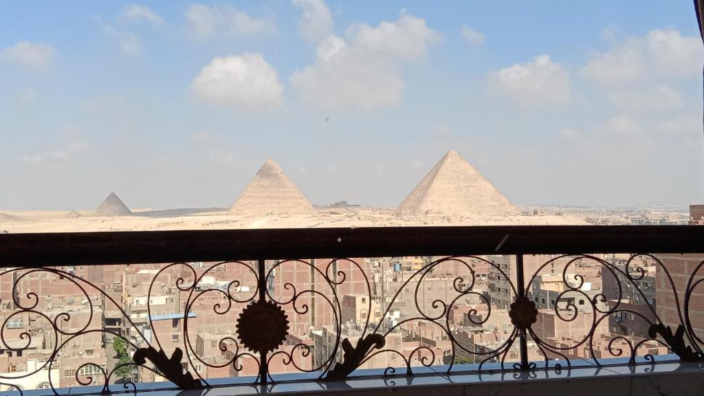 a view of the pyramids from a balcony of a building at Isis Guest House in Cairo