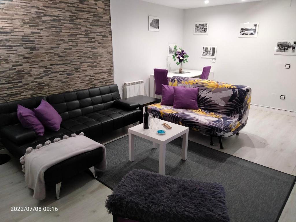 - un salon avec un canapé noir et des oreillers violets dans l'établissement El Rincón de La Maña, à Logroño