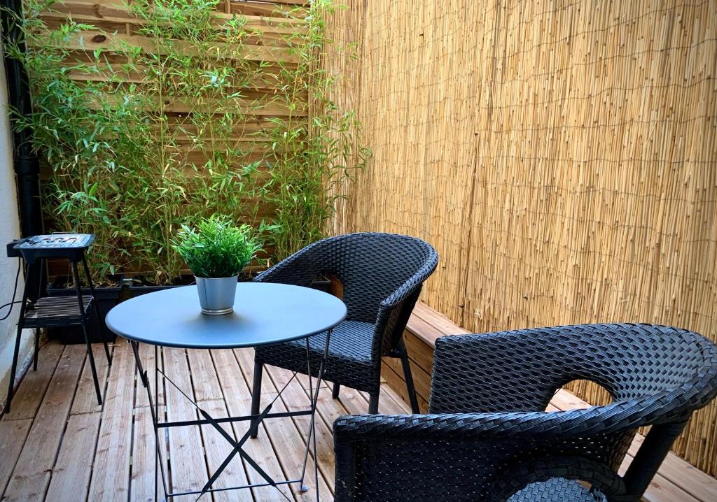 une table et des chaises sur une terrasse avec une plante dans l'établissement Petit Studio Terrasse Toulon Vieille Ville, à Toulon