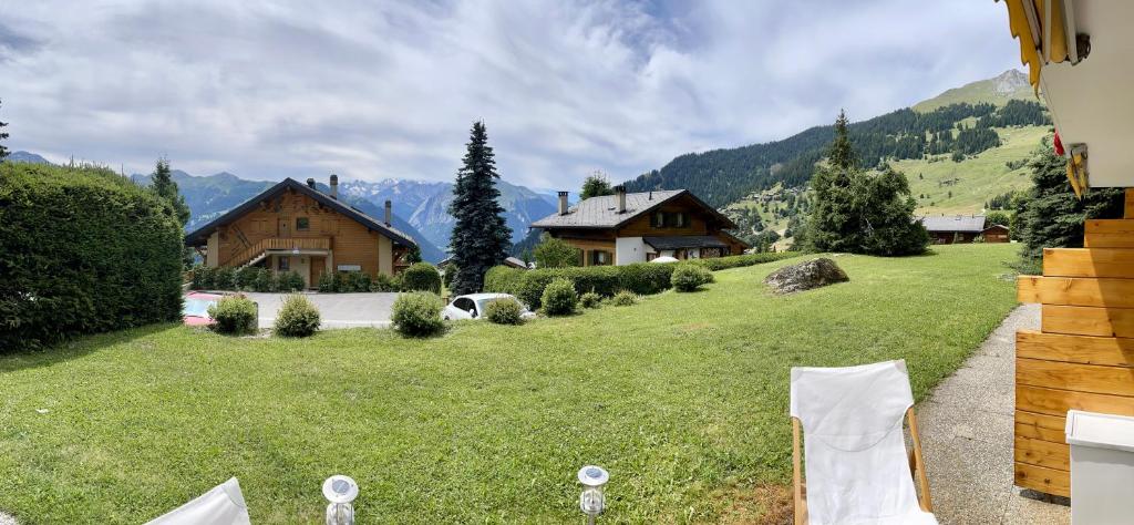 a grassy yard with a house in the background at Appartement 2-pieces à Verbier in Verbier