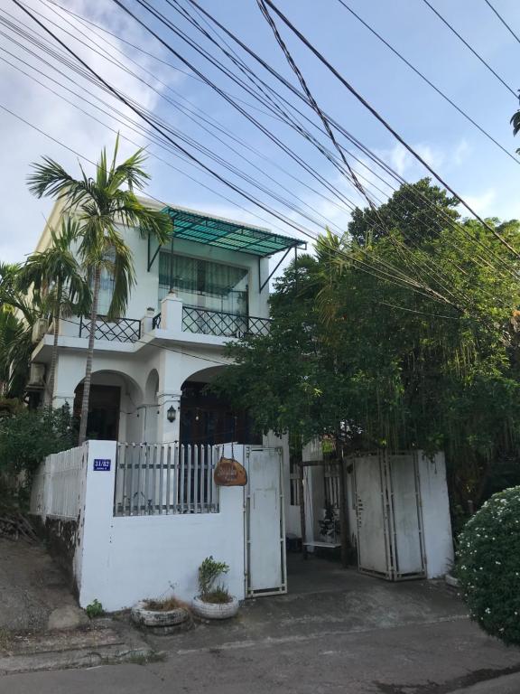 una casa blanca con una puerta y una valla en Lam Vien Homestay Hue en Hue