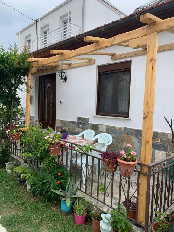 a patio with plants and a wooden pergola at BACI HOUSE in Limenas