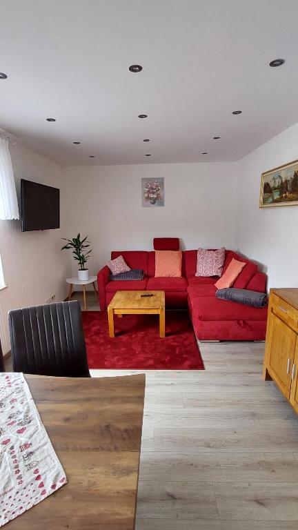 a living room with a red couch and a table at Ferienwohnung Fovere in Kall