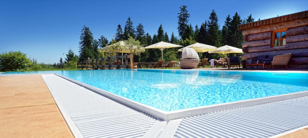 a large swimming pool in front of a house at Natur- und Sporthotel Zuflucht in Freudenstadt