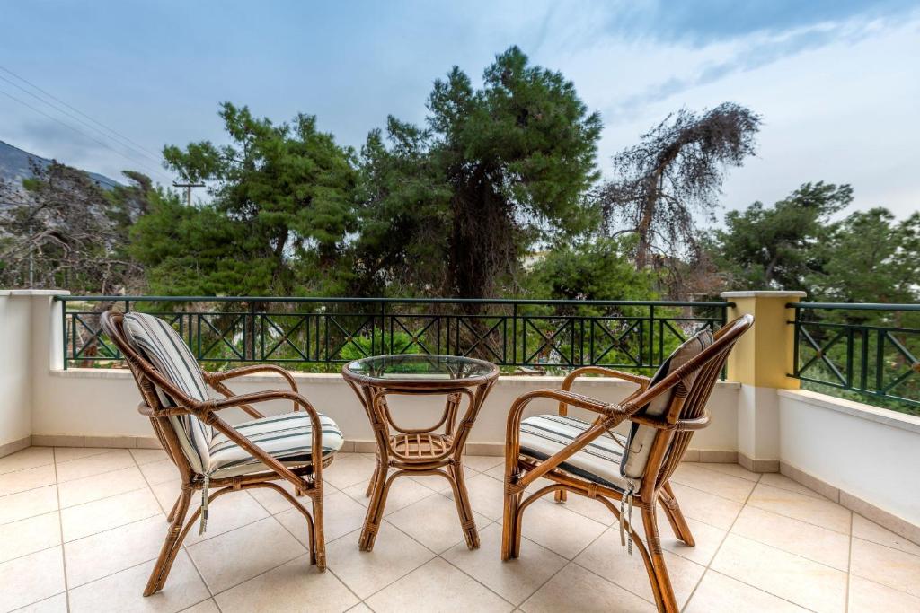 2 stoelen en een glazen tafel op een balkon bij J Studios - Kineta Seaside Retreats in Kineta