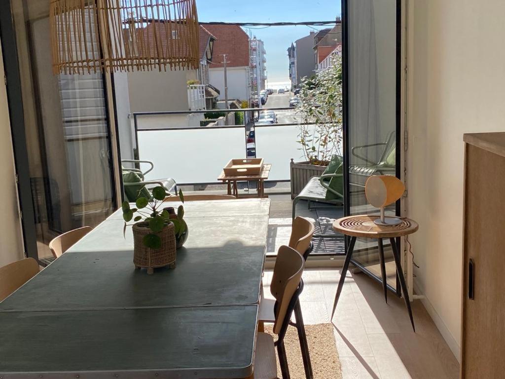 a room with a table and chairs on a balcony at Le dodo mauricien in Wimereux