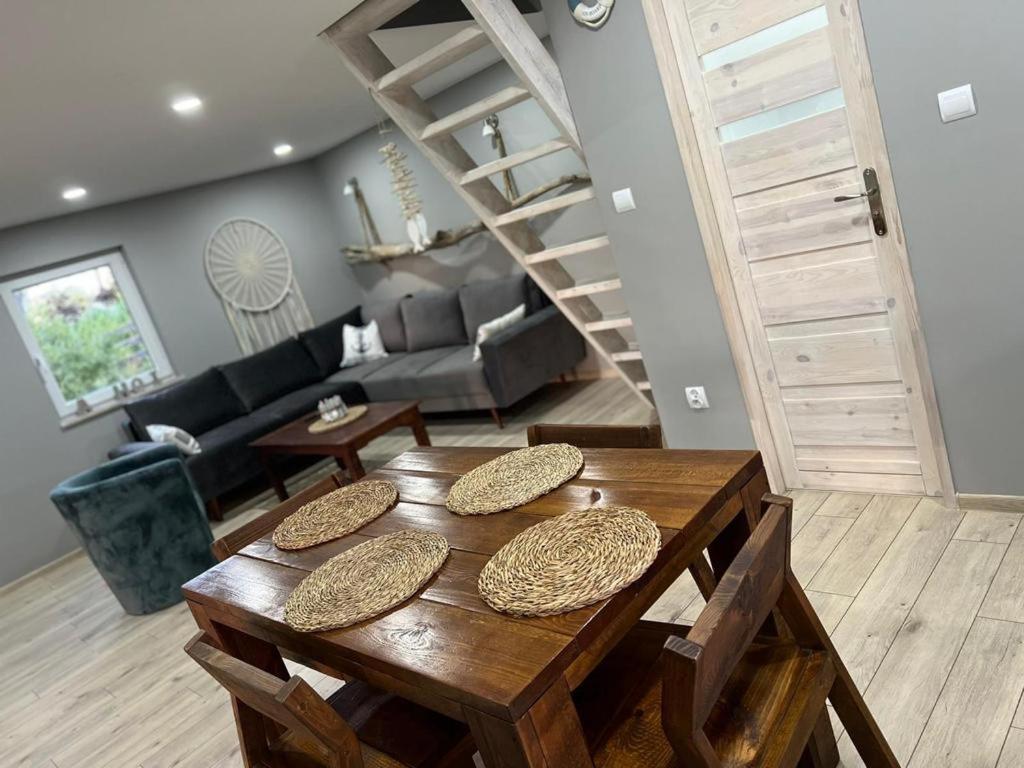 une pièce avec une table en bois et un salon dans l'établissement Domek nad jeziorem, à Myślibórz