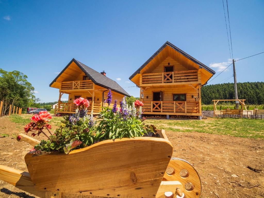 a log cabin with a flower pot in front of it at Domki nad rzeką w Komańczy in Komańcza