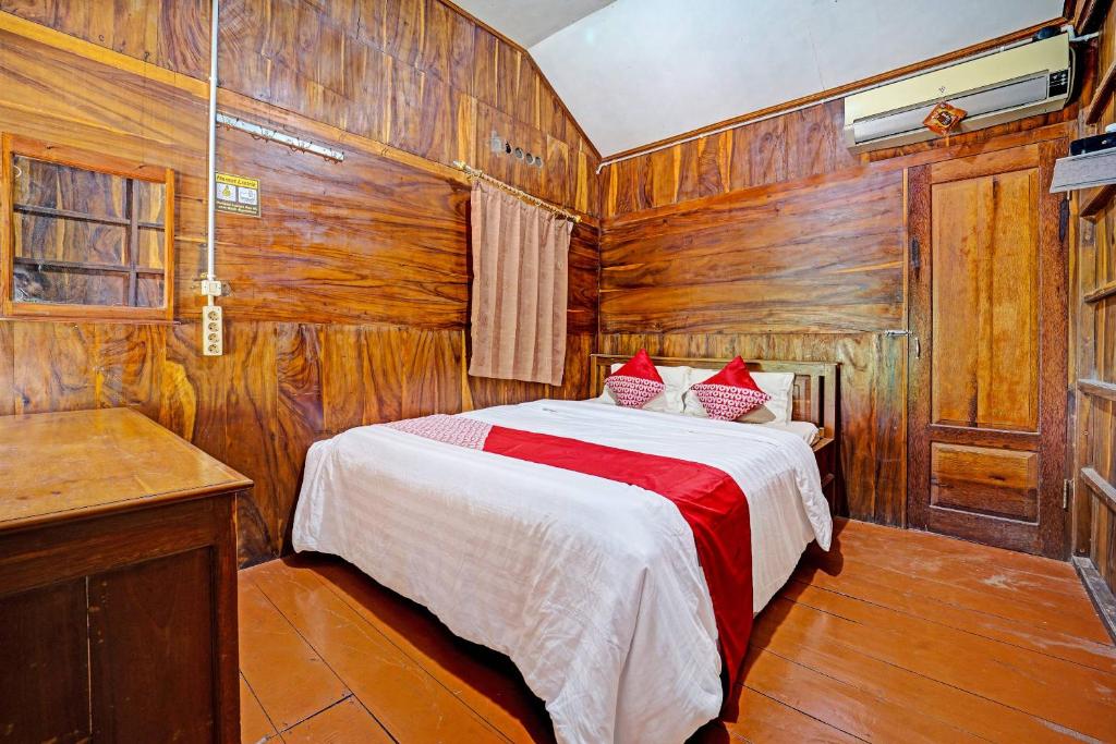 a bedroom with a bed in a wood paneled room at OYO Life 91201 Larasati Homestay Pantai Klayar in Pacitan
