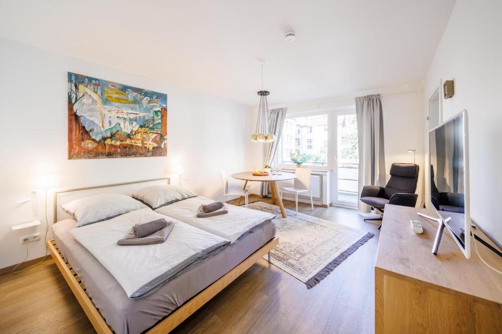 ein Schlafzimmer mit einem großen Bett und ein Wohnzimmer in der Unterkunft Glück Auf Appartements Rüttenscheiderstraße Essen in Essen