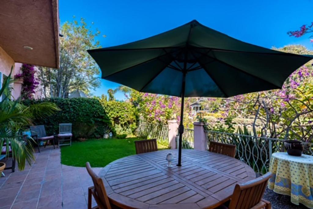 a wooden table with an umbrella on a patio at Villa 3 bedrooms on Venice Beach Canal. in Los Angeles