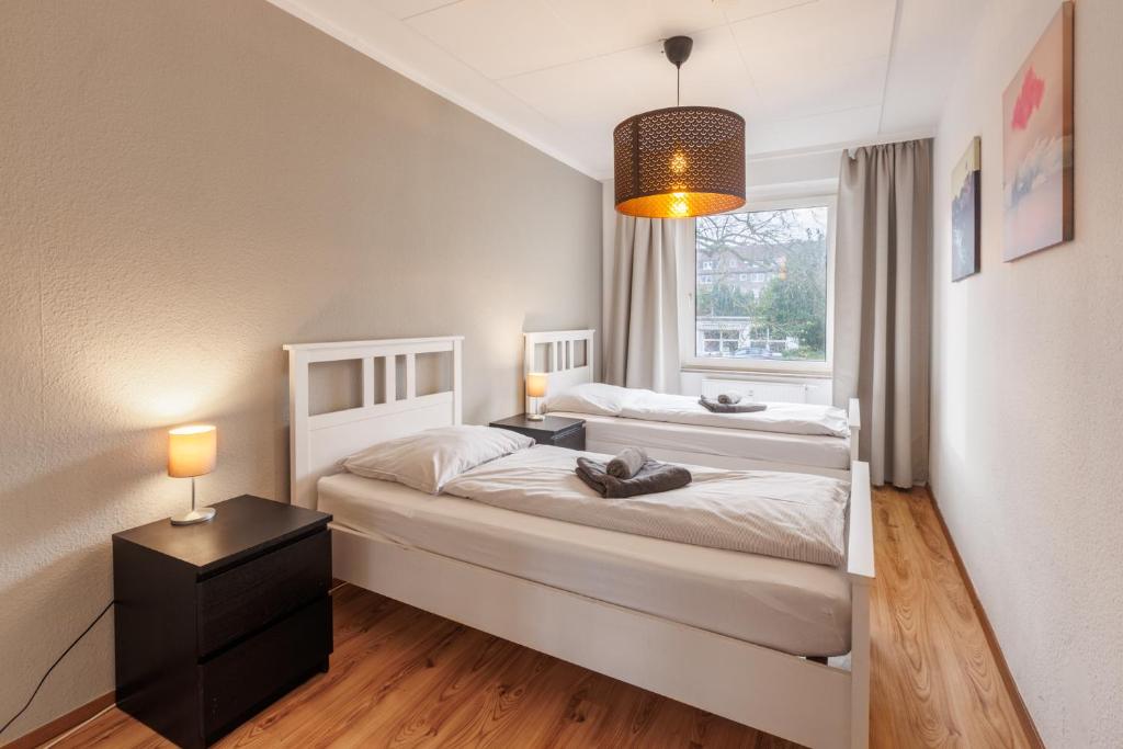 1 dormitorio con 2 camas y ventana en Glück Auf Monteurswohnungen Schederhofstraße Essen, en Essen
