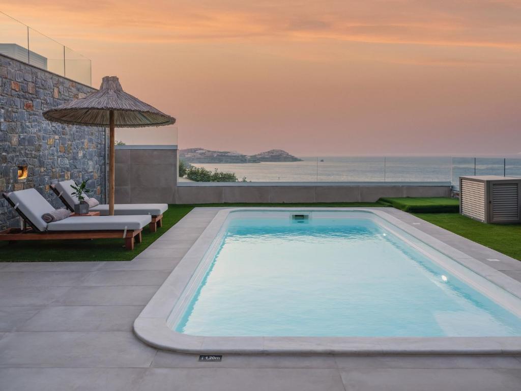 a swimming pool with a view of the ocean at Ligaria Mare in Agia Pelagia
