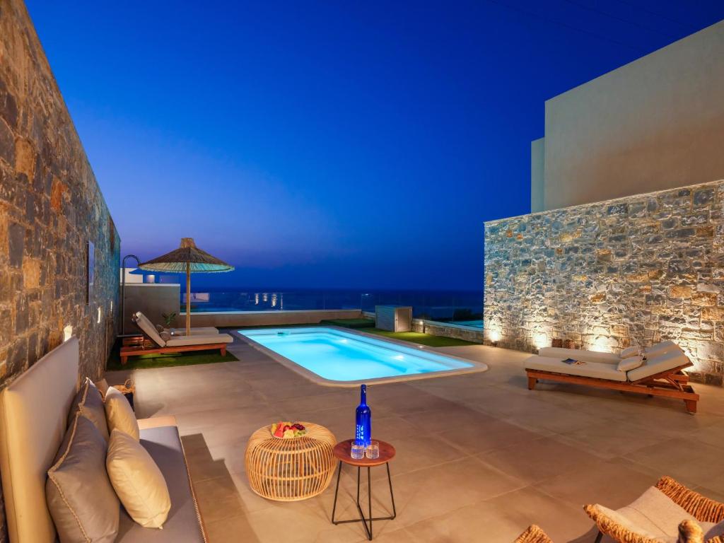 a villa with a swimming pool at night at Ligaria Mare in Agia Pelagia