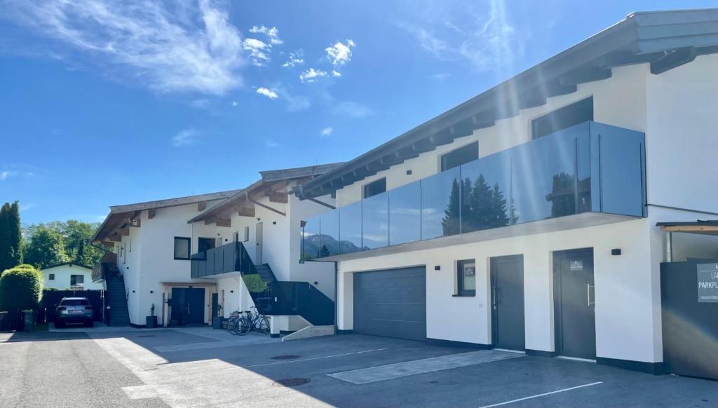 ein großes weißes Gebäude mit viel Glas in der Unterkunft Apartments Lakeside 29 Zell am See in Zell am See