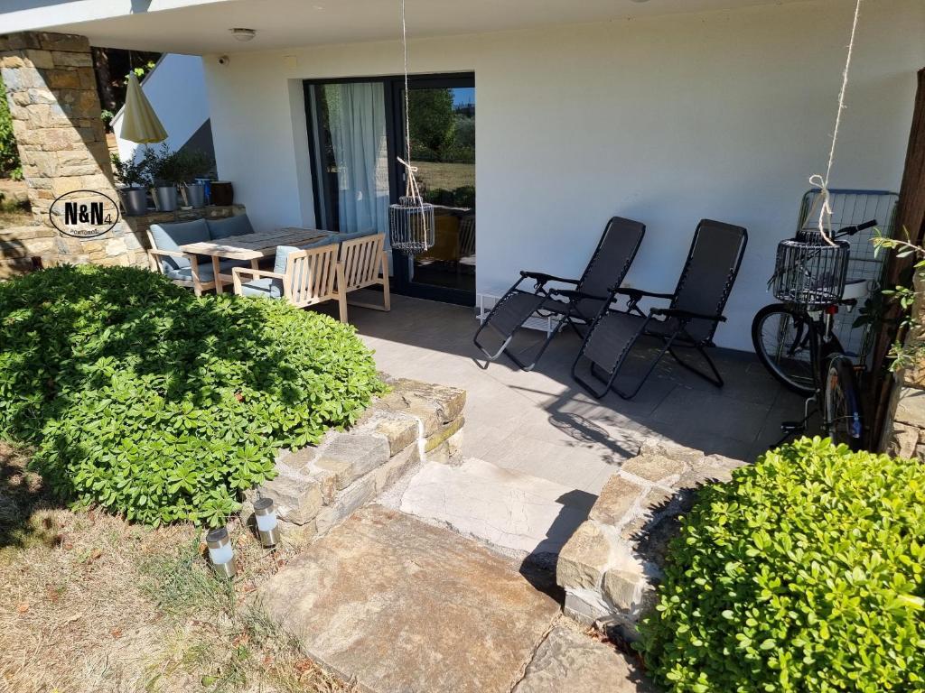 eine Terrasse mit Stühlen und einem Tisch in einem Haus in der Unterkunft N&N Apartments and Rooms by Locap Group in Portorož