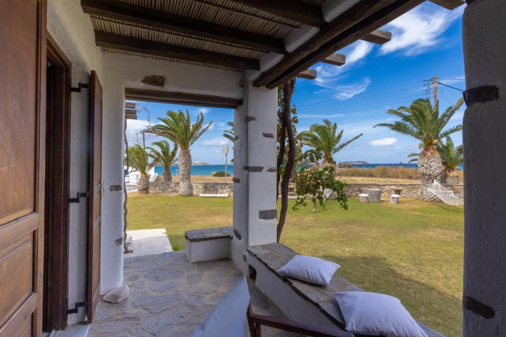 a porch with a view of the ocean and palm trees at Sunset Pounda in Pounda