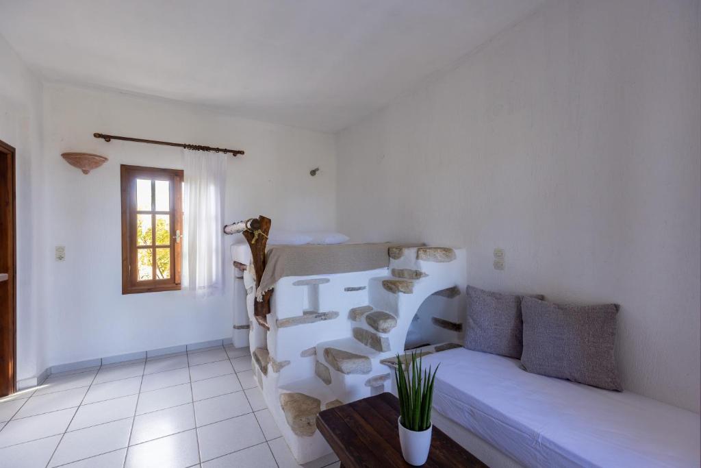 a white living room with a couch and a table at Sunset Pounda in Pounda