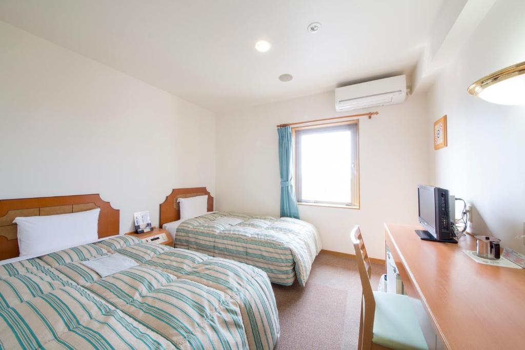 Postel nebo postele na pokoji v ubytování Hyper Hotel Komatsu