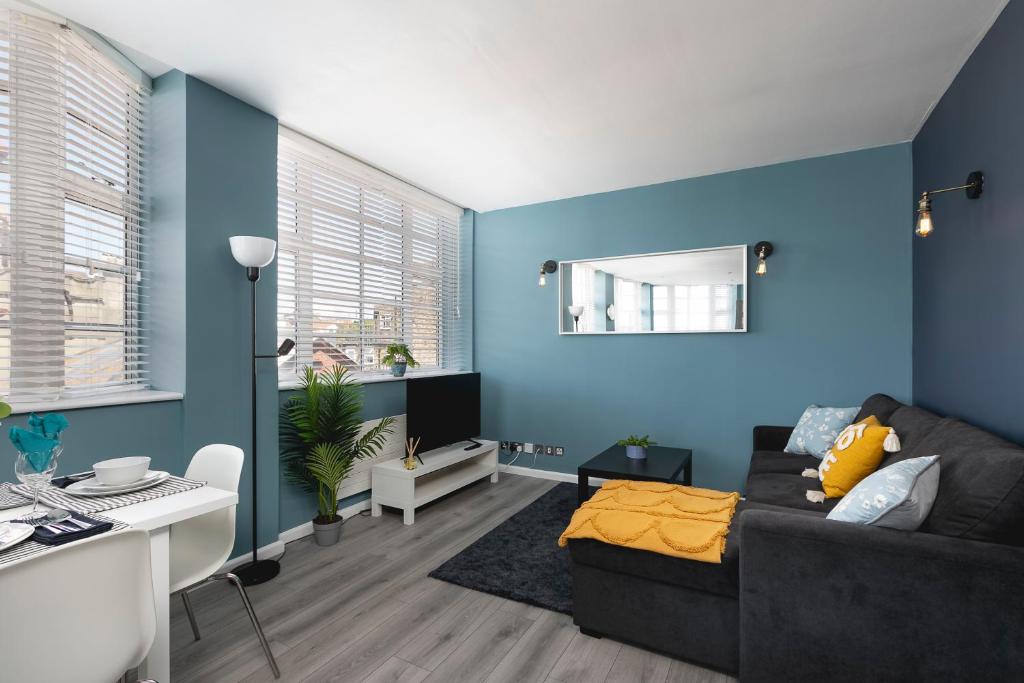 a living room with blue walls and a couch at Lovely Brighton Apartments Moments Away From Royal Pavilion in Brighton & Hove