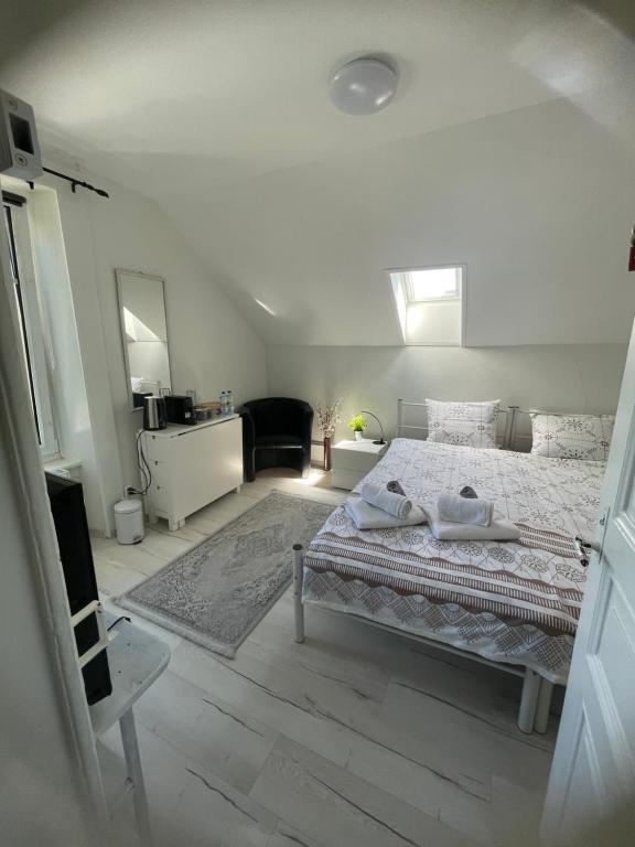 a white bedroom with a bed and a mirror at La Maison Bleue à 2 pas du Lac du Neuchâtel in Hauterive