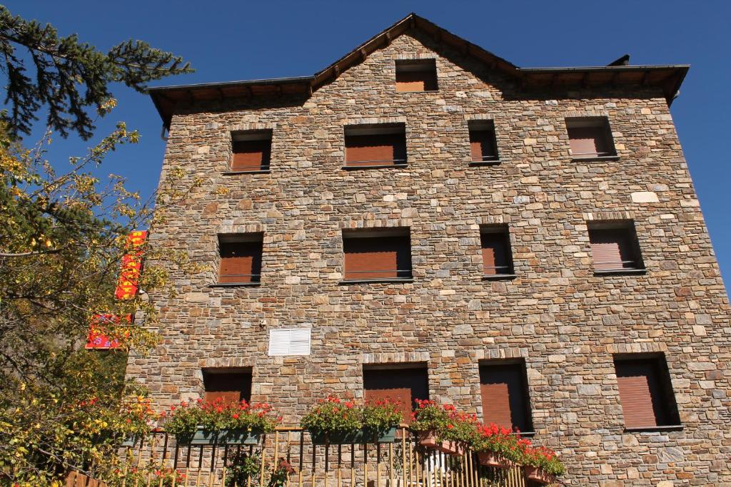 a brick building with windows and a fence at Apartaments Vilaró in Llorts