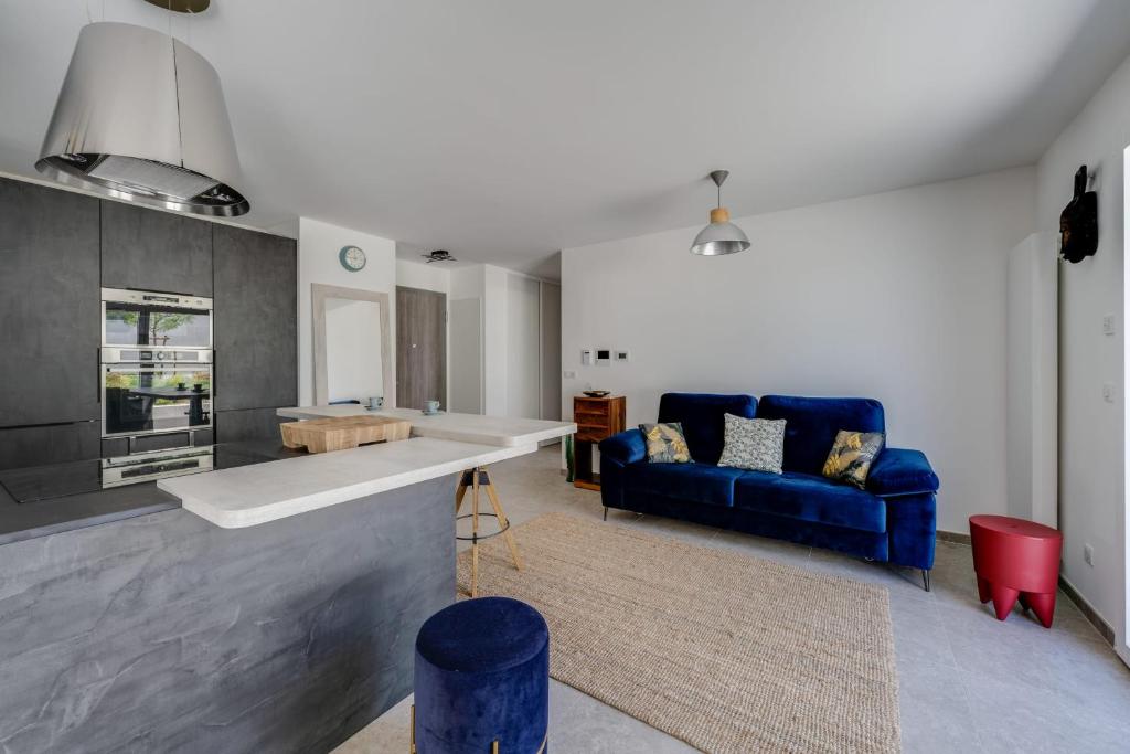 sala de estar con sofá azul y cocina en Envie de Lac - Nice T3 for 6 people near Beach en Annecy