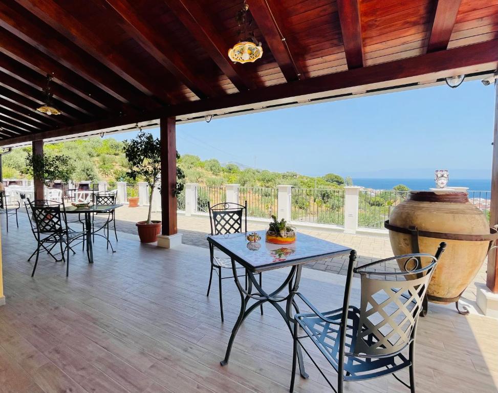 a patio with tables and chairs and a large vase at Agriturismo Bella Vista - Da Carmelo in Santa Teresa di Riva