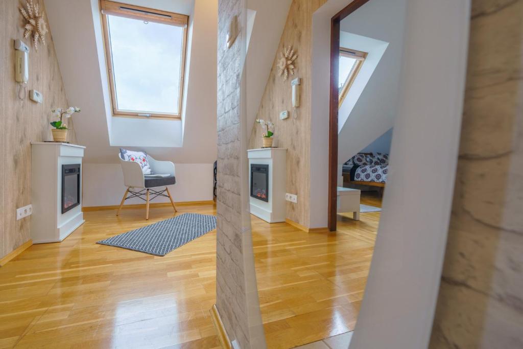 a living room with a staircase and a chair at LOFT FOLK Apartament Zakopane in Zakopane