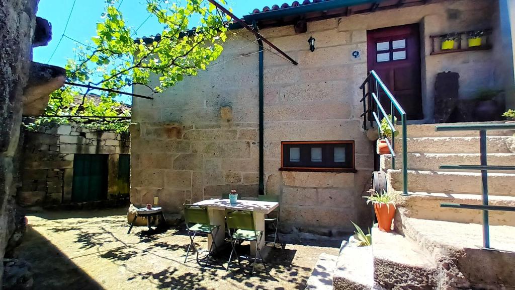 une table dans la cour d'un bâtiment dans l'établissement 2 bedrooms house with furnished terrace and wifi at Lindoso, 