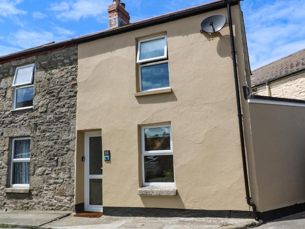 an old stone house with a window at Chough Cottage in Penzance