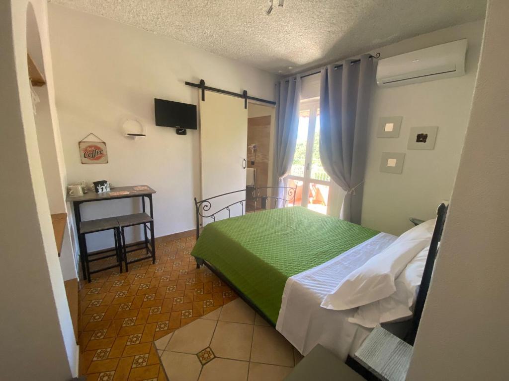 a bedroom with a bed and a table and a window at B&B Felice in Maratea