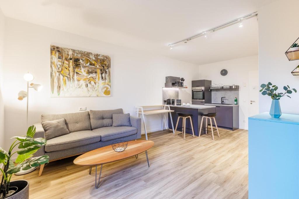 uma sala de estar com um sofá e uma mesa em Glück Auf Appartements Düppelstraße em Oberhausen