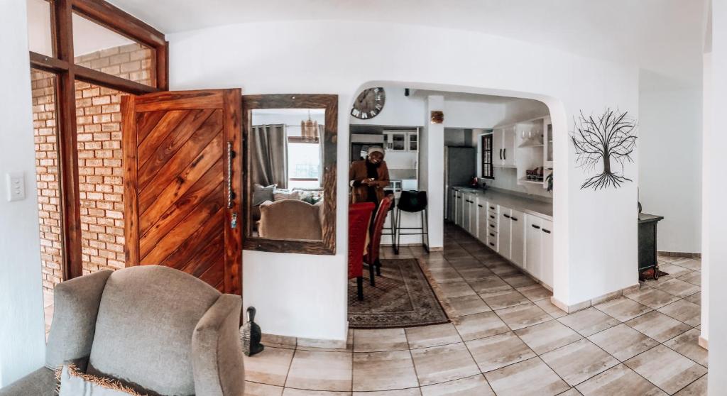 een woonkamer met een deur naar een keuken bij Gold Pot Stay a 5 bedroom House in Pretoria