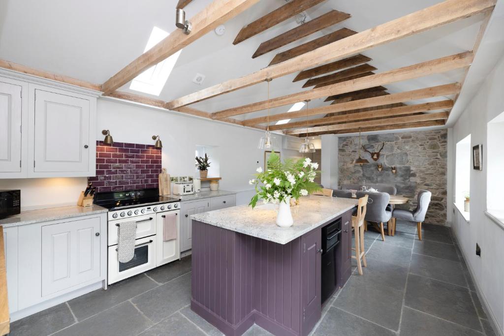 una cocina con armarios blancos y una isla púrpura en Exceptional cottage with parking, en Blairgowrie