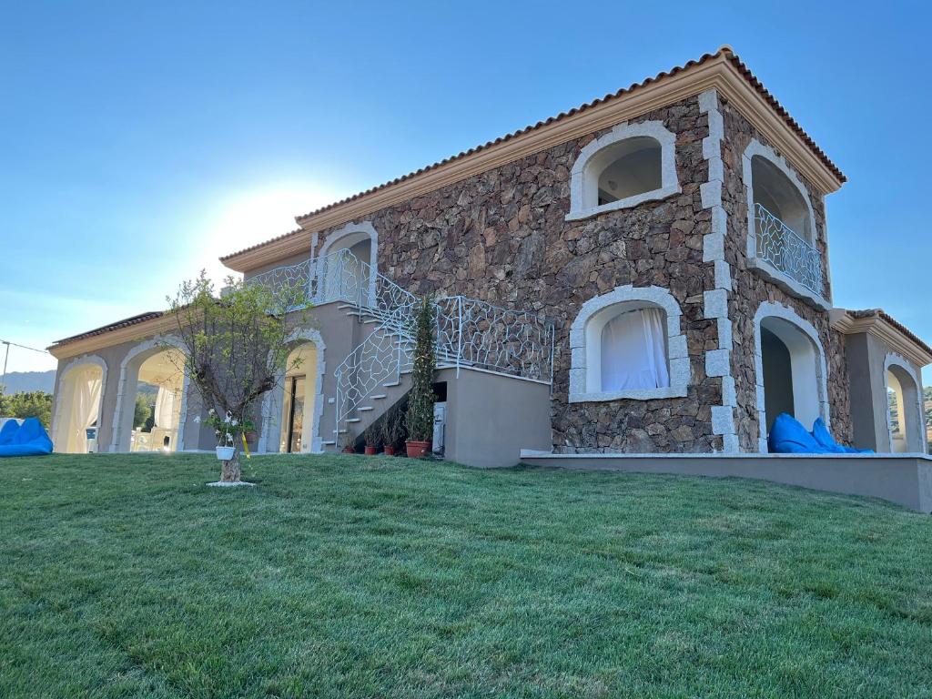 a large stone house with a grass yard at LAMEFATA in San Teodoro