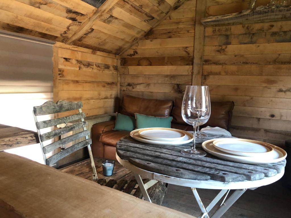 einen Tisch mit Tellern und Weingläsern darauf in der Unterkunft Une Maison à la Campagne in Durbuy