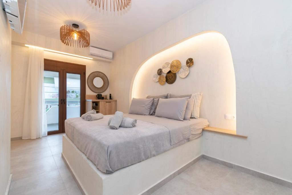 ein weißes Schlafzimmer mit einem großen Bett in einem Zimmer in der Unterkunft IOSIF suites in Neos Marmaras