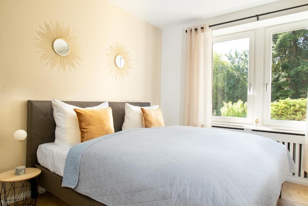 a bedroom with a bed with two mirrors on the wall at Löwe Apartment Gold Tiengen Altstadt in Waldshut-Tiengen