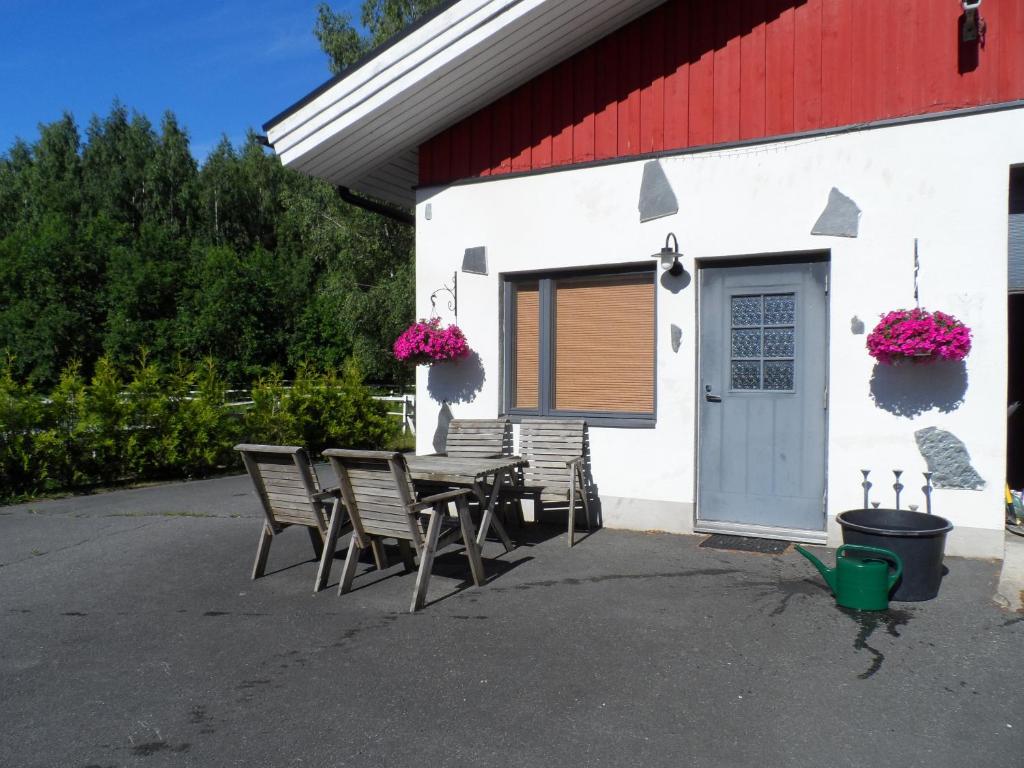 een groep stoelen en een tafel buiten een gebouw bij Walhalla apartment in Forssa