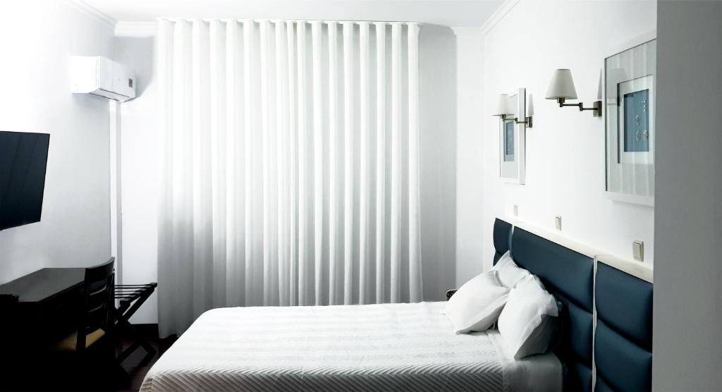 ヴィラ・ノーヴァ・デ・フォス・コアにあるHotel Vale Do Côaのベッドと大きな窓のある寝室