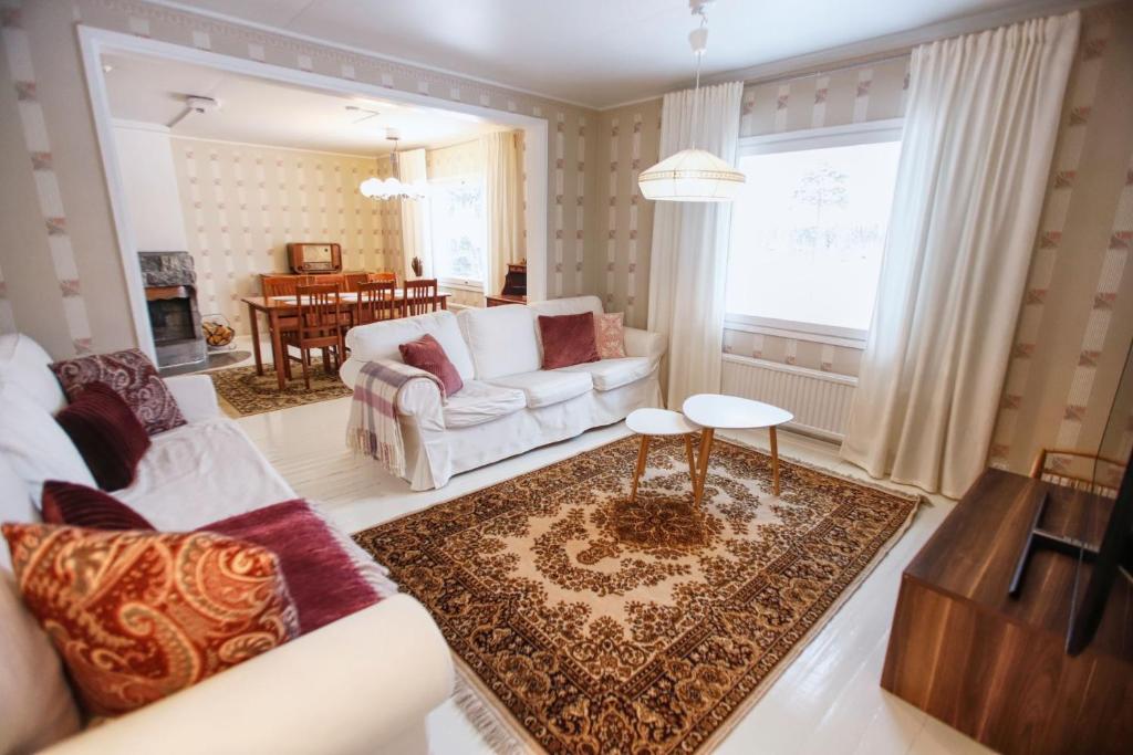 ein Wohnzimmer mit einer Couch und einem Tisch in der Unterkunft Kotolinna, Kotomo Oy in Paltamo